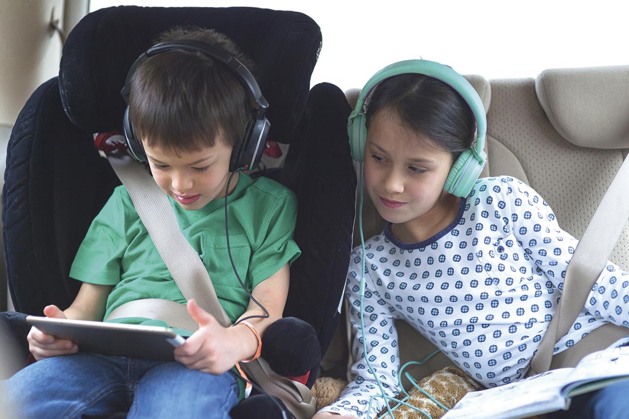 2 kids looking at tablet in backseat of car