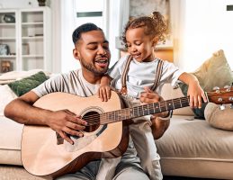 father and daughter playing guitar