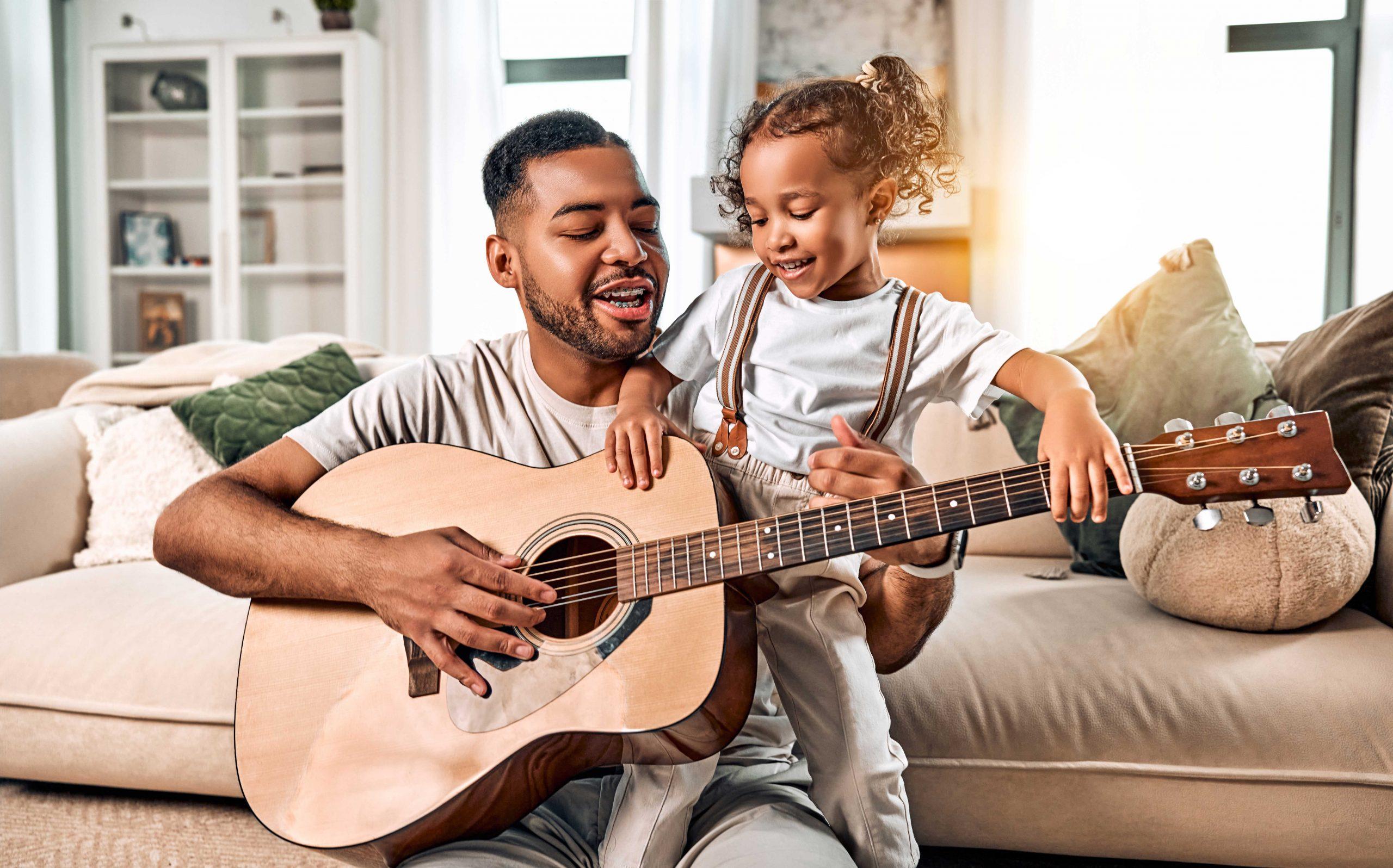 father and daughter playing guitar