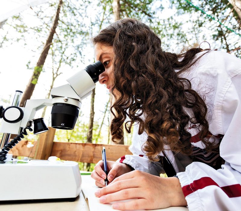 Toronto Waldorf School student looking at microscope