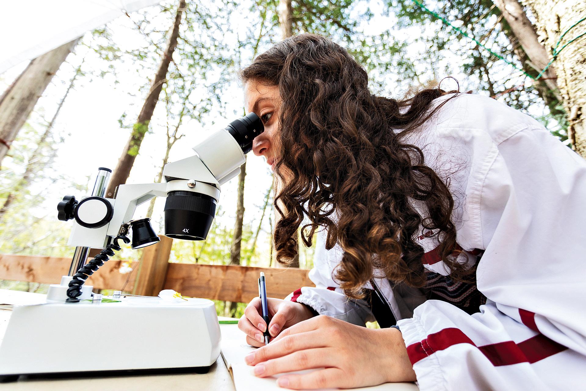 Toronto Waldorf School student looking at microscope