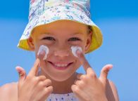 little girl putting sunscreen