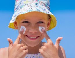 little girl putting sunscreen