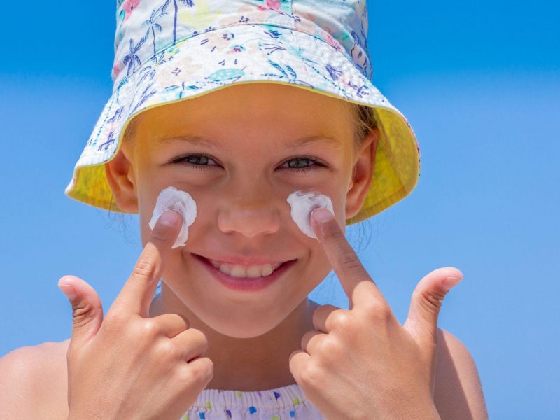 little girl putting sunscreen