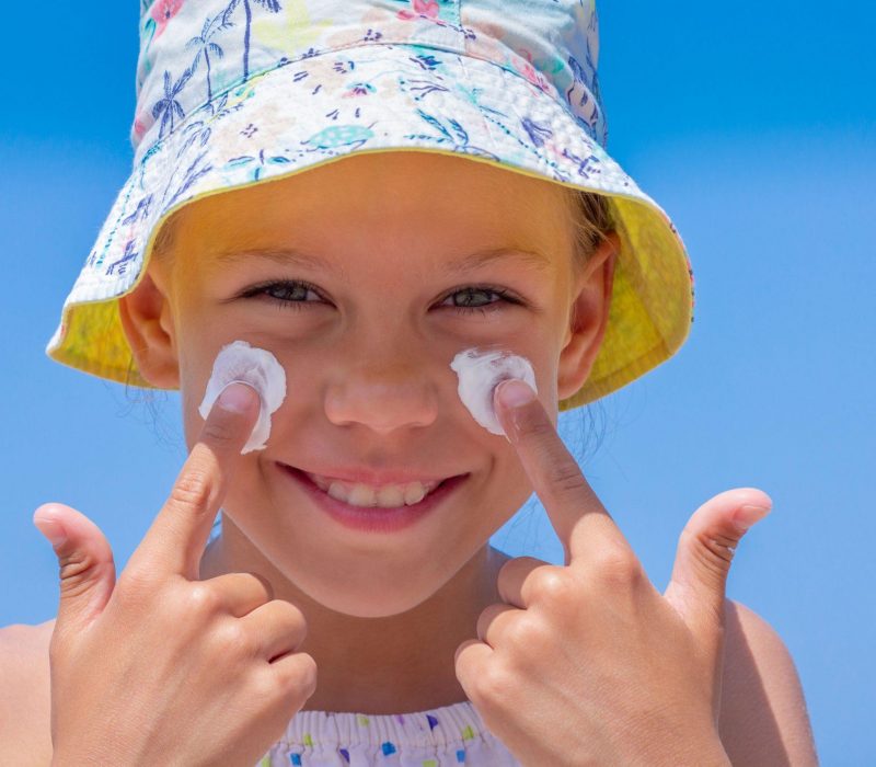 little girl putting sunscreen