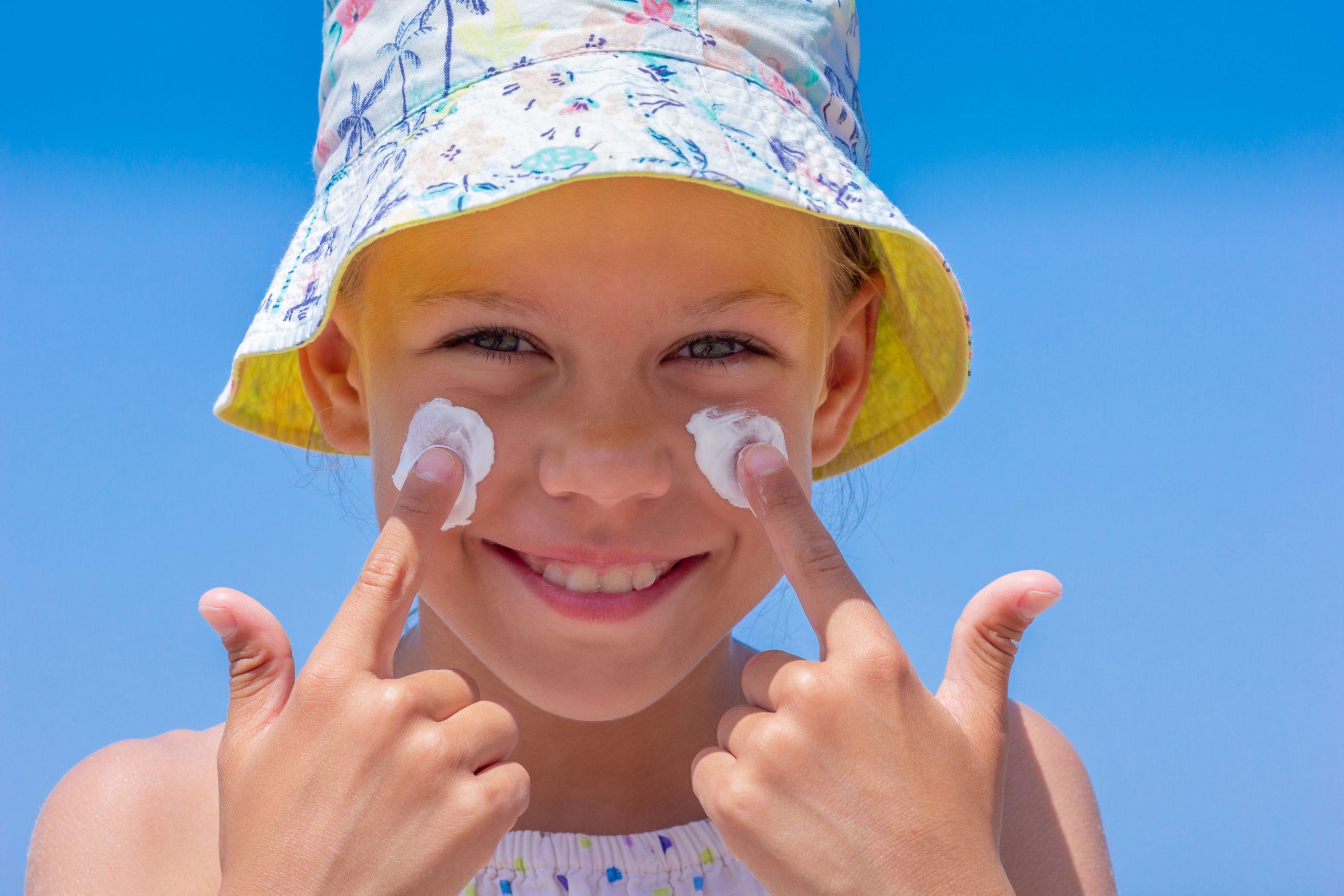 little girl putting sunscreen