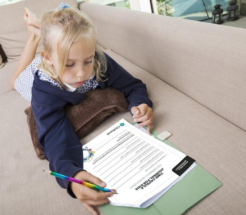 Little girl solving mathematics sums on sofa