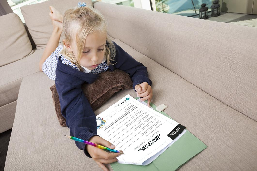 Little girl solving mathematics sums on sofa
