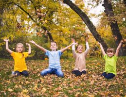 Group of kids throwing autumn leaves