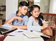 two kids watching on their phone during studying