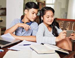 two kids watching on their phone during studying