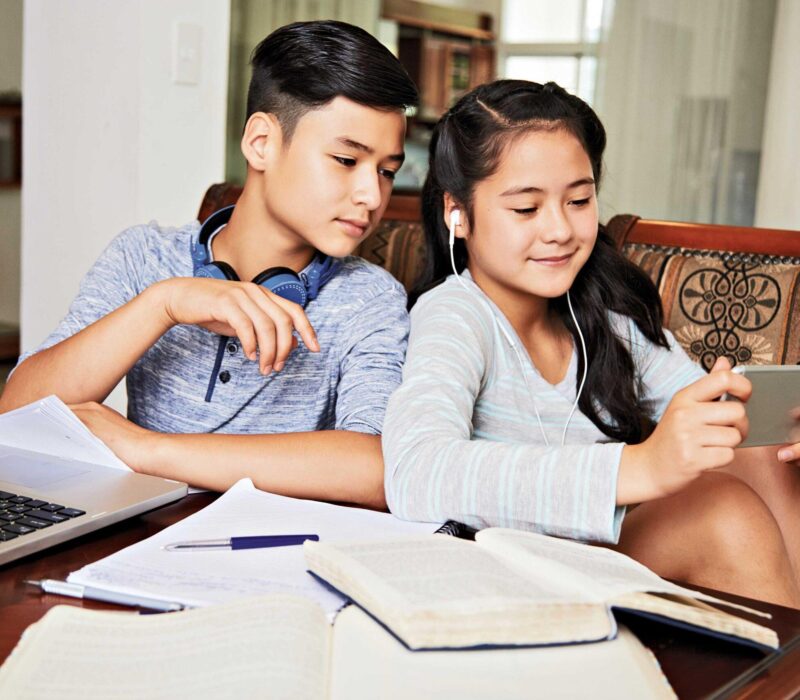 two kids watching on their phone during studying